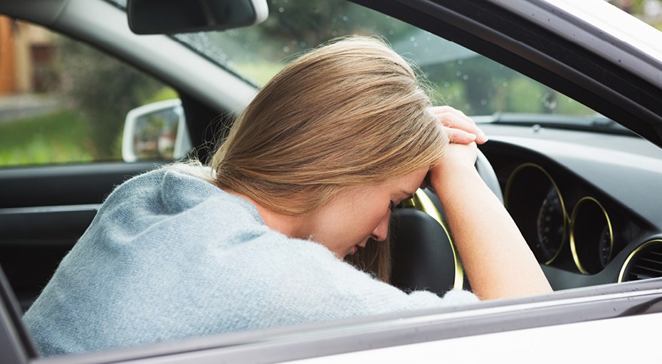 Alumna con la cabeza apoyada sobre el volante tras el examen práctico